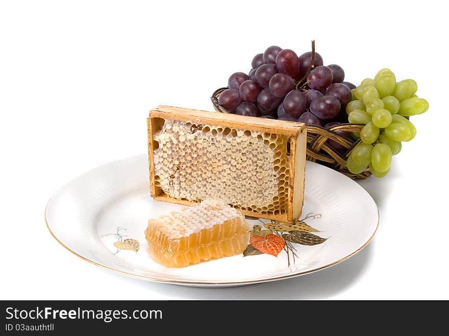 Honeycomb in border with grapes on dish