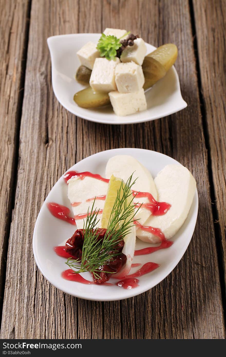 Slices of mozzarella and cubes of marinated feta cheese. Slices of mozzarella and cubes of marinated feta cheese