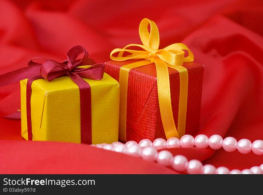 Box with a gift on a red fabric still life