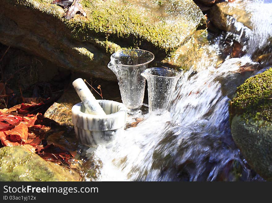 Two glasses and bowl in a stream. Two glasses and bowl in a stream