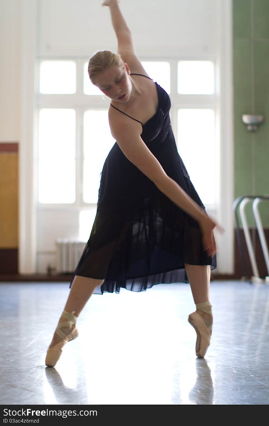 A dancer wearing point shoes practices in a studio. A dancer wearing point shoes practices in a studio