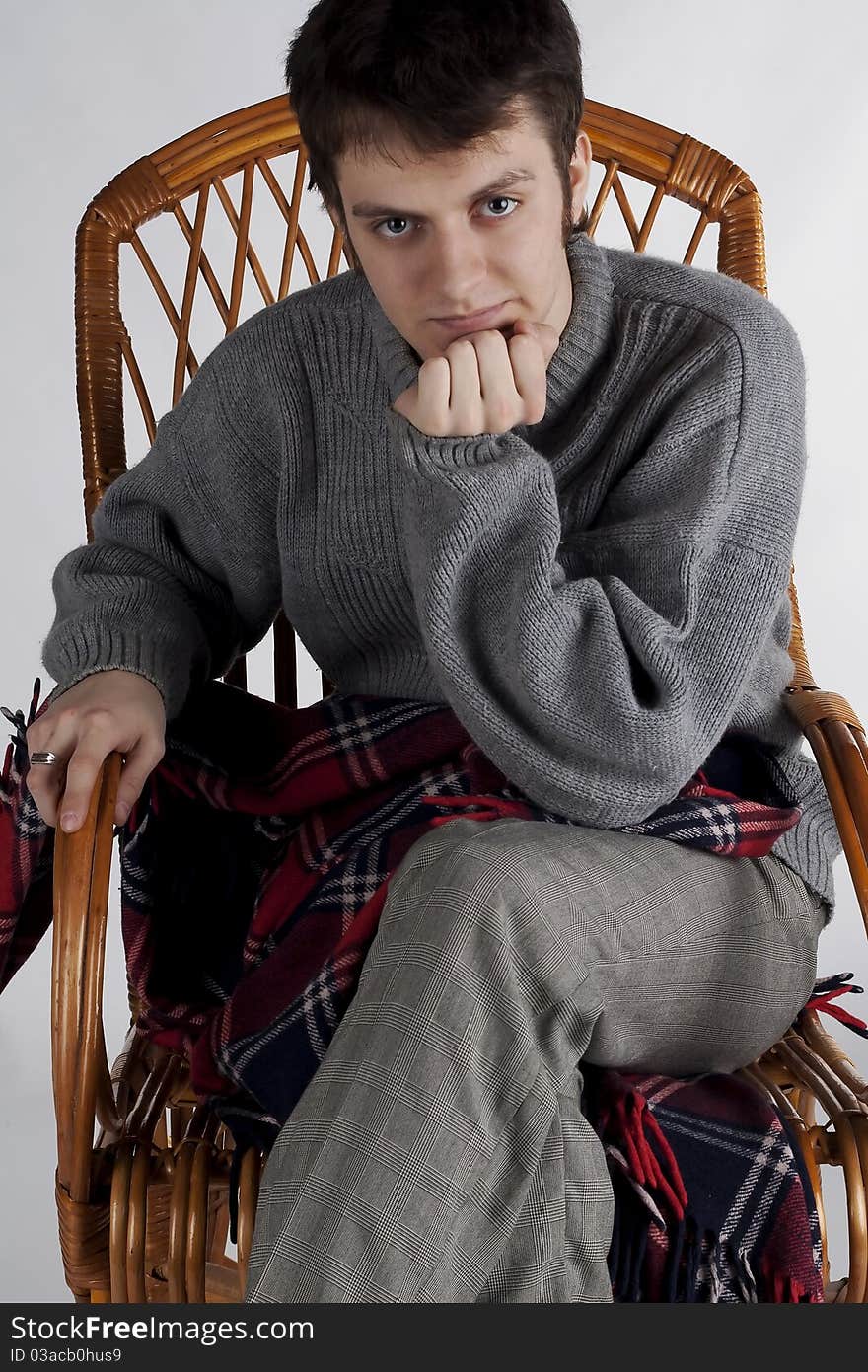 Portrait of a young man in a rocking chair in the studio