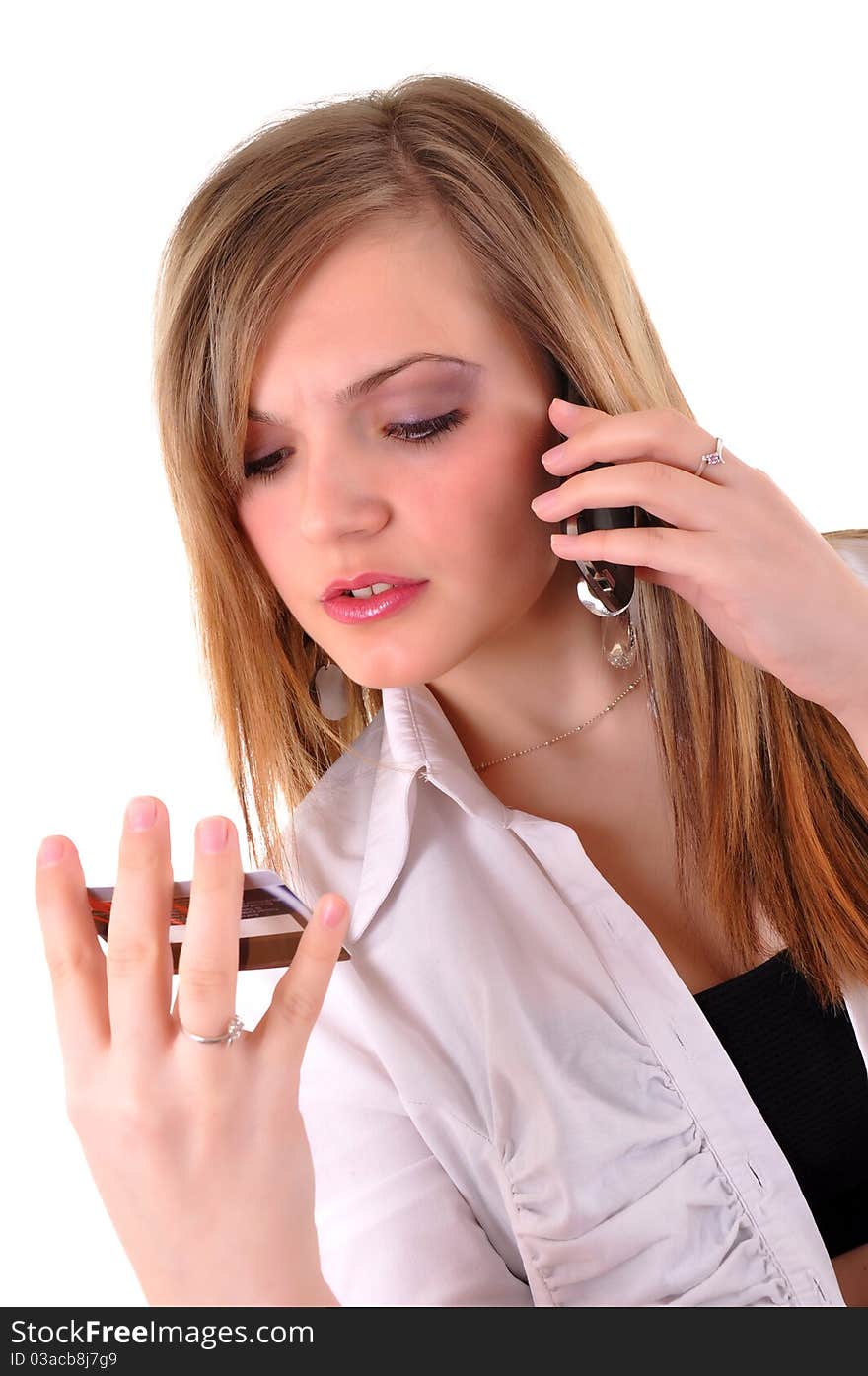 Young woman with a credit card speaking on phone