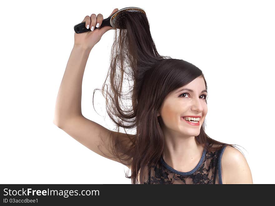 The beautiful girl smiling combs to itself hair. The beautiful girl smiling combs to itself hair