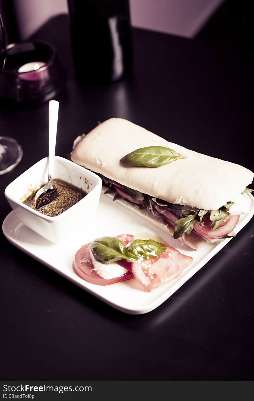 Long baguette sandwich with ham,  fresh vegetables and pesto. Long baguette sandwich with ham,  fresh vegetables and pesto