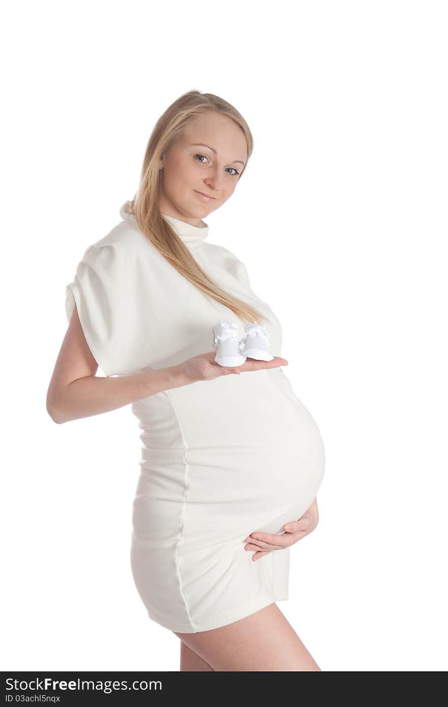 Pregnant young woman, holding baby's bootees. Pregnant young woman, holding baby's bootees.