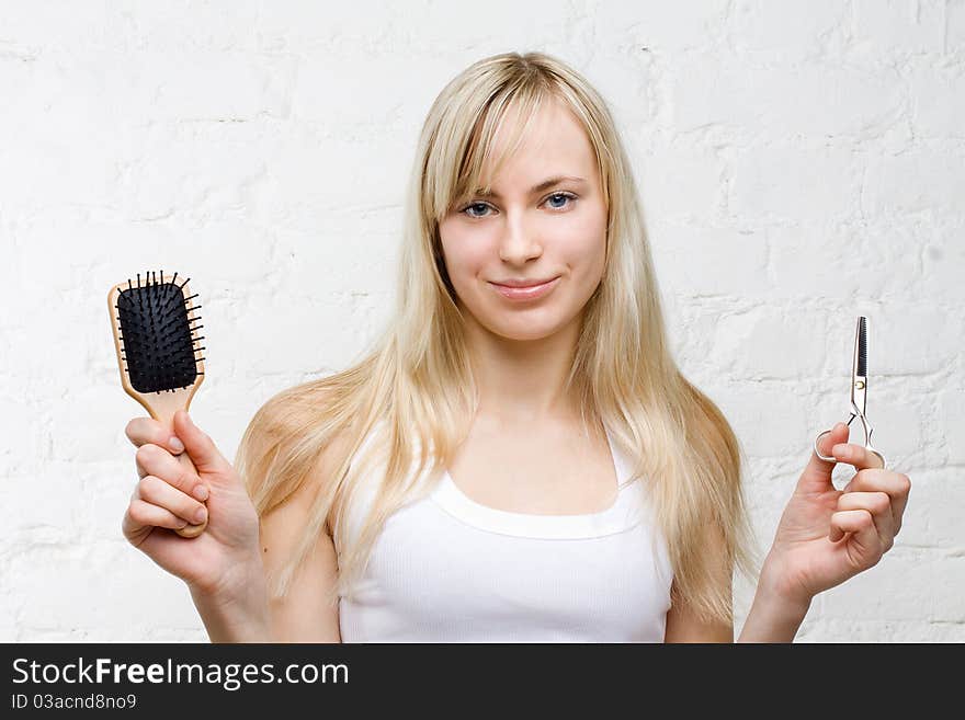 Smiling woman holding comb and scissors - beauty industry