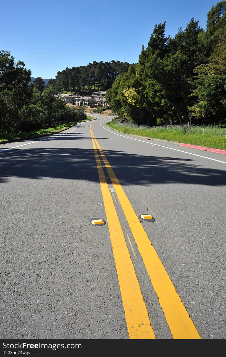 Road leads down a hill in the summer. Middle of the road life. Road leads down a hill in the summer. Middle of the road life.