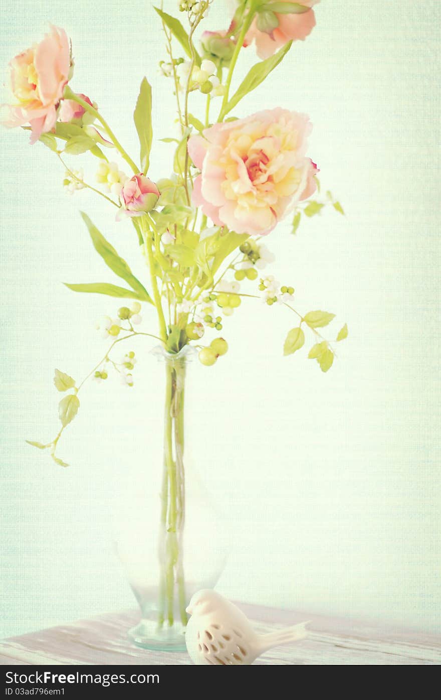 A still life of spring flowers with a porcelain bird figurine. A still life of spring flowers with a porcelain bird figurine.