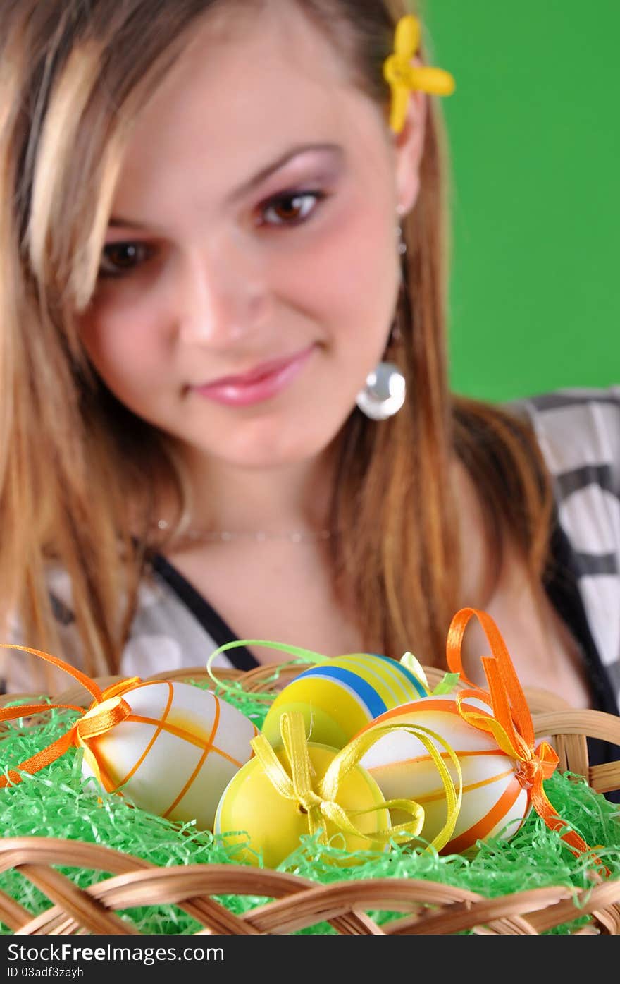 Young beautiful girl with basket and easter eggs in her hand