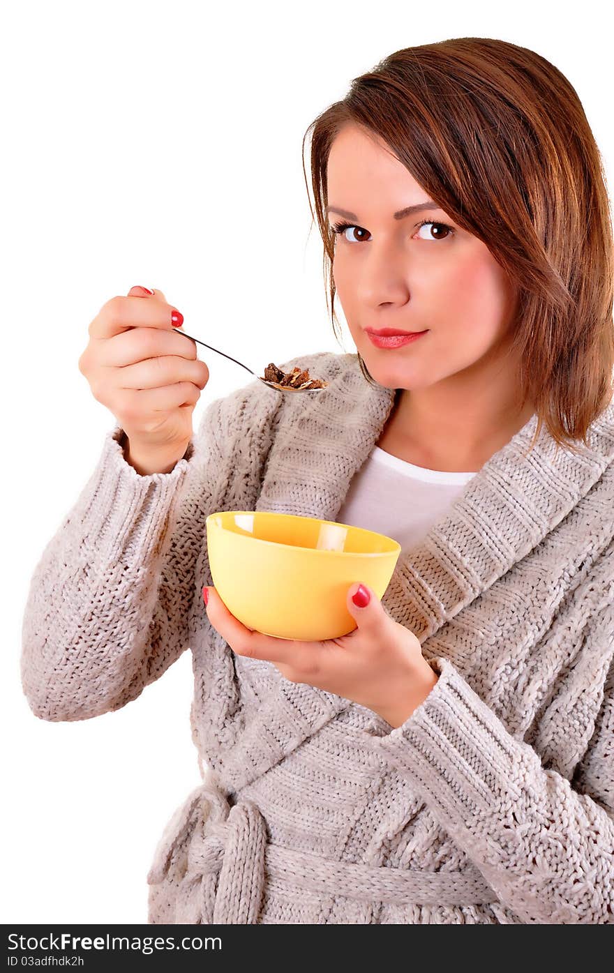 Portrait of young smiling woman eating muesli or cornflakes, isolated on white background