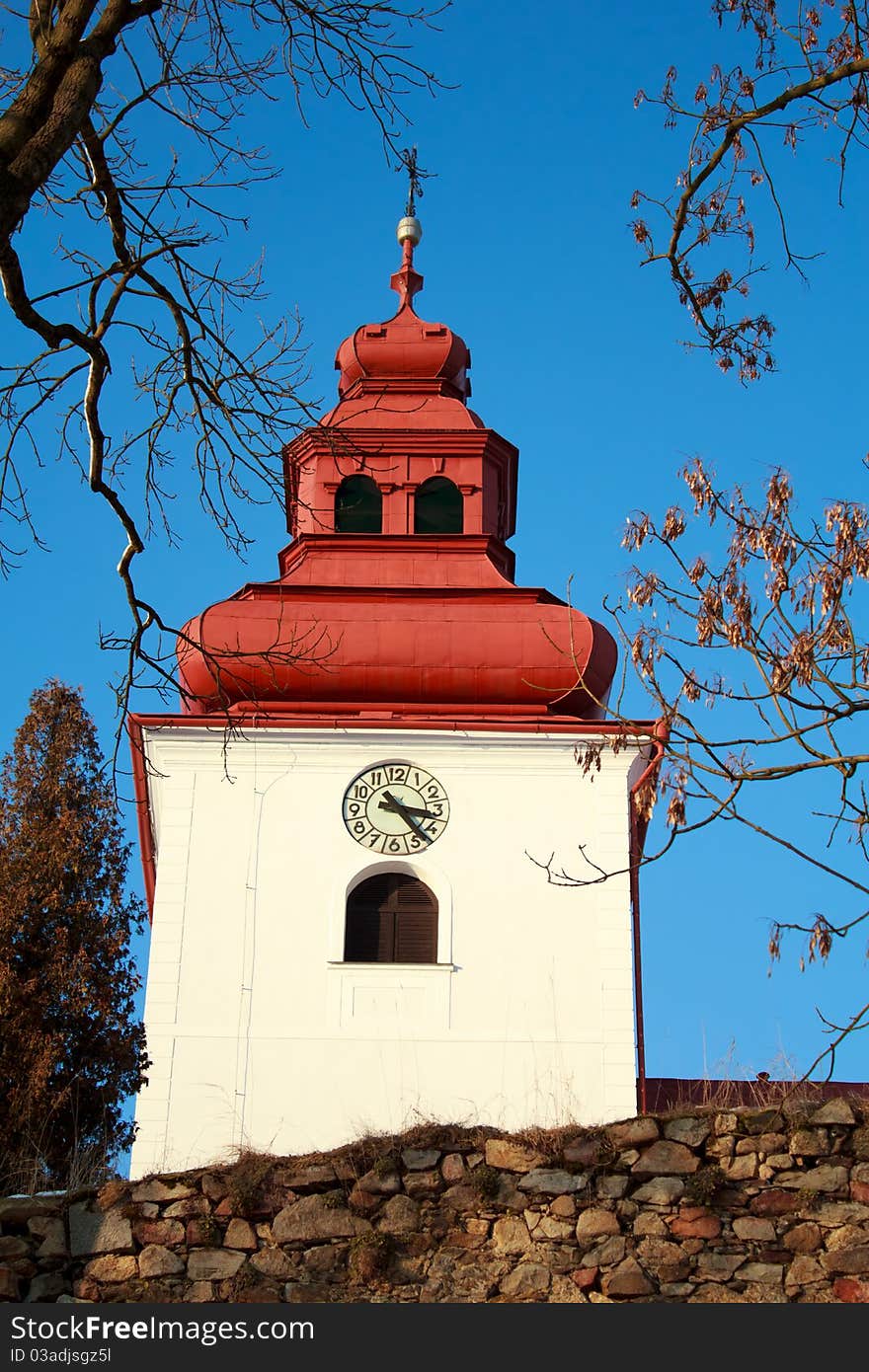 Catholic church with steeple clock and blue sky