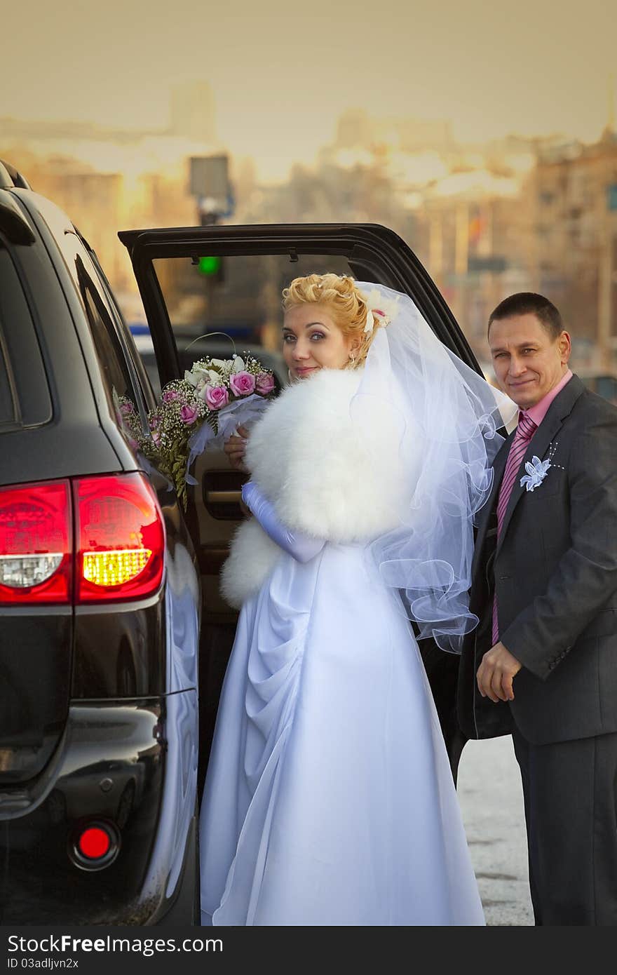 Happy bride and groom going in wedding car. Happy bride and groom going in wedding car