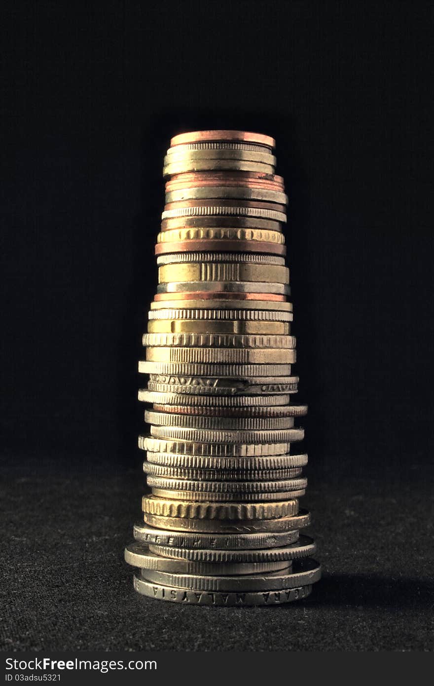 Different international coins with different size and shape make a column. Different international coins with different size and shape make a column