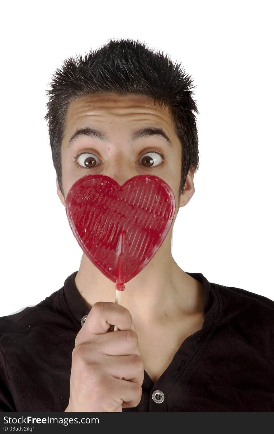 Pakistani teenage boy is looking surprised at a lolly heart. Pakistani teenage boy is looking surprised at a lolly heart