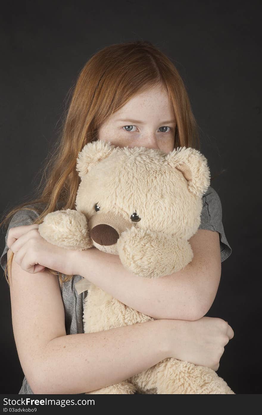 Young girl is cuddling with a teddybear