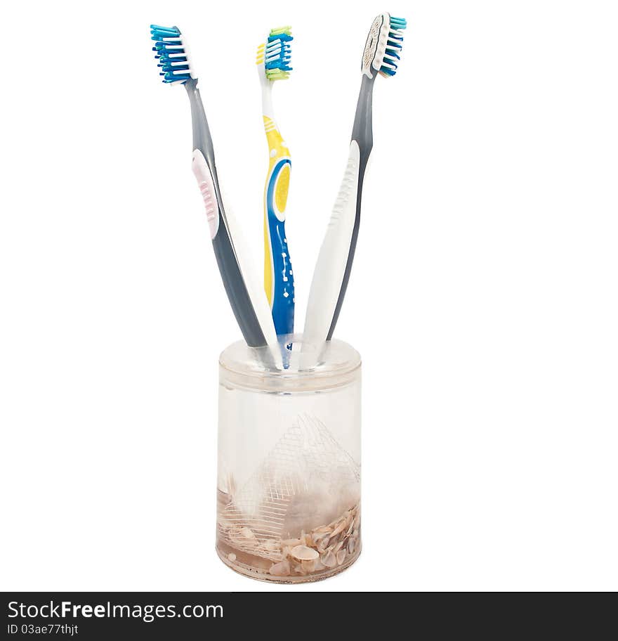 Toothbrushes in a glass on a white background