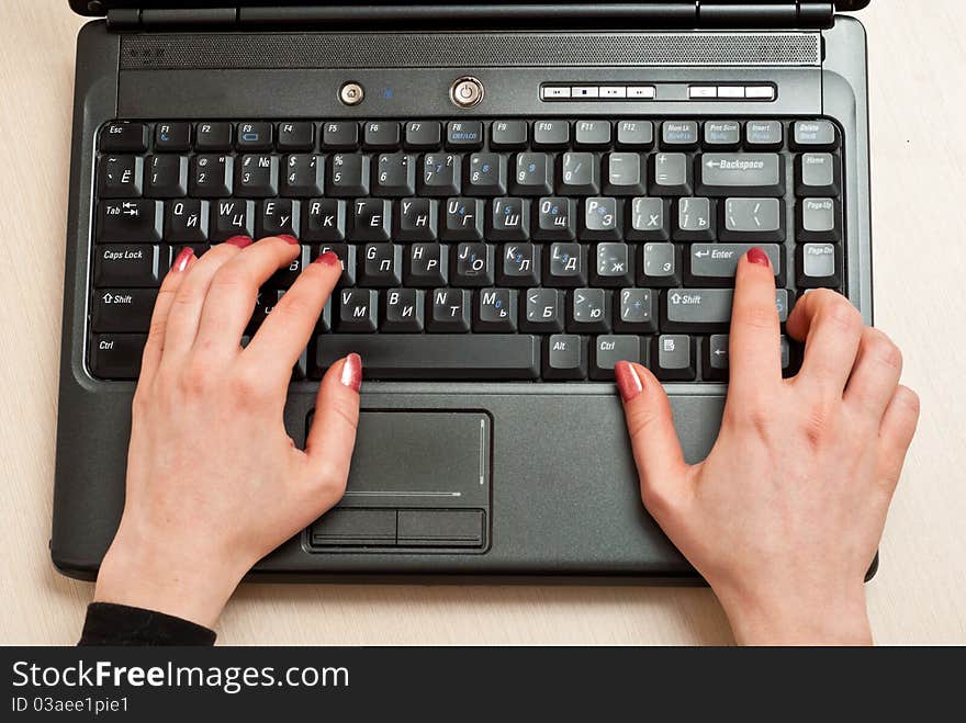 Female hands typing on laptop keyboard