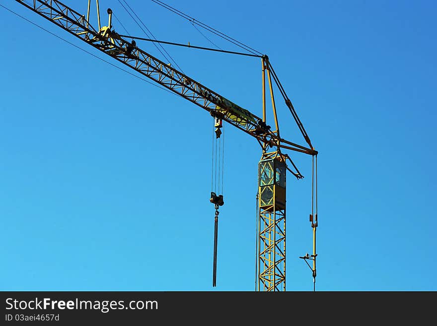 Crane holding a prefabricated element against a limpid sky. Crane holding a prefabricated element against a limpid sky