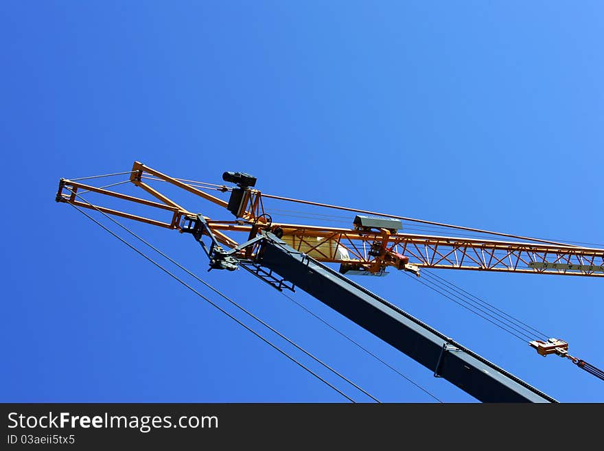 Crane holding a prefabricated element against a limpid sky. Crane holding a prefabricated element against a limpid sky