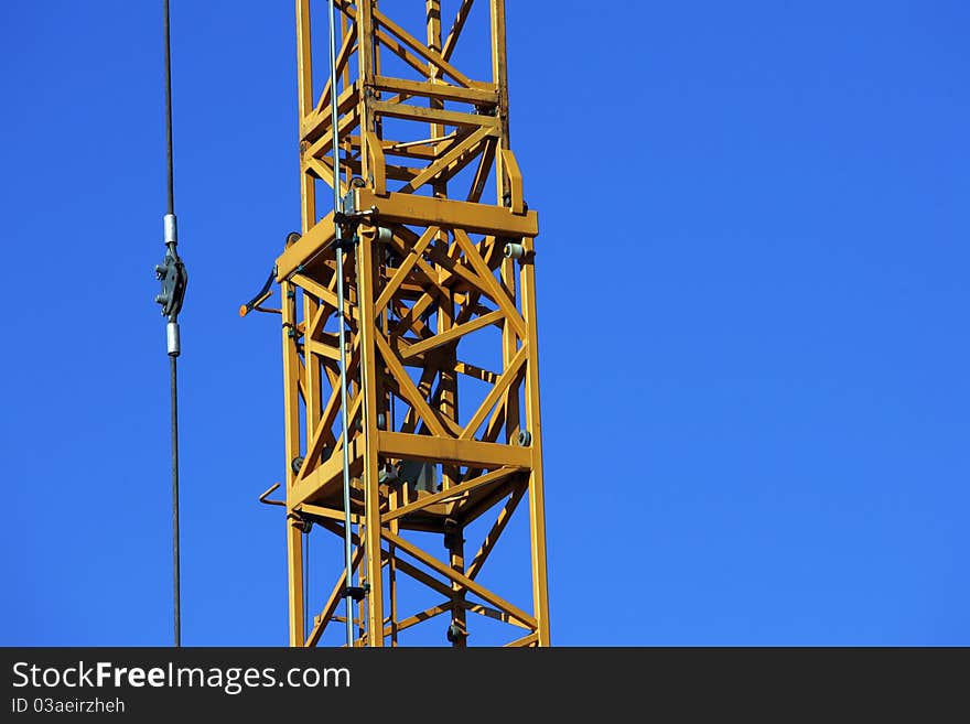 Crane holding a prefabricated element against a limpid sky. Crane holding a prefabricated element against a limpid sky