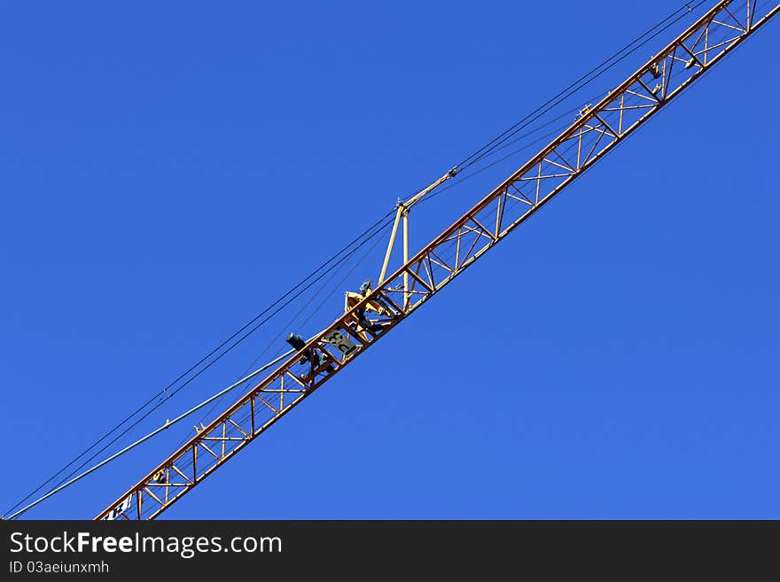 Crane holding a prefabricated element against a limpid sky. Crane holding a prefabricated element against a limpid sky