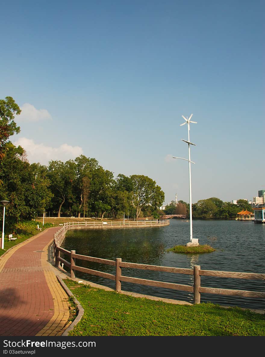 A windmill be encircled with lake in park. A windmill be encircled with lake in park