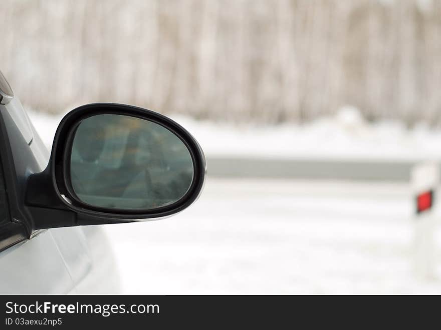 Car mirror on the background of a winter forest