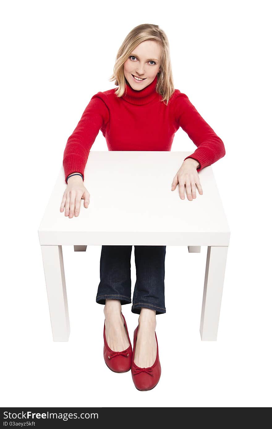 Young woman sitting at funny small desk