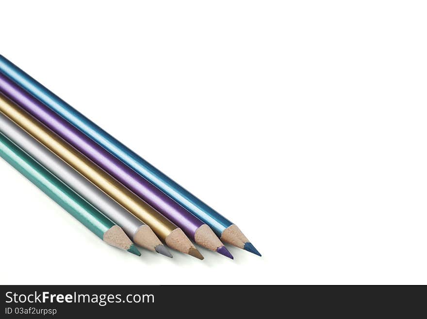 Five metalic color pencils on a white background.