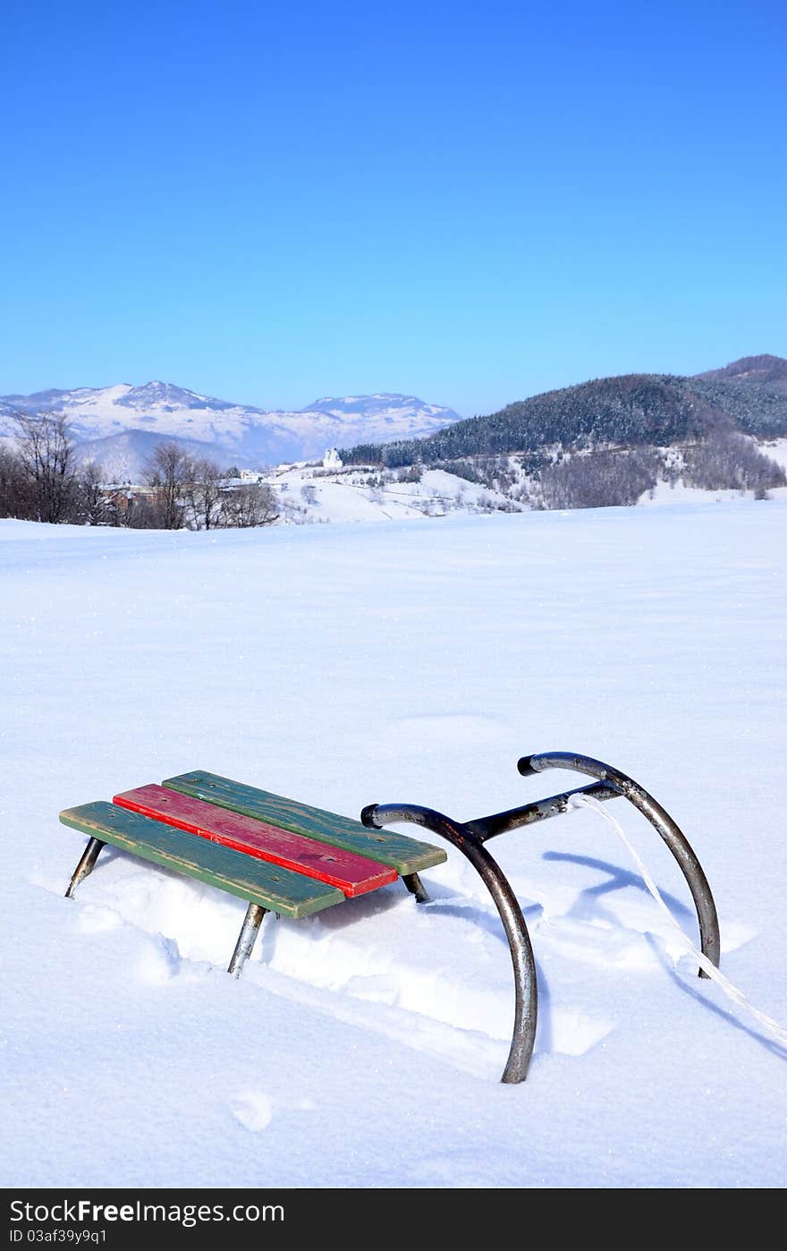 Old sledge with snow and mountine in background. Old sledge with snow and mountine in background