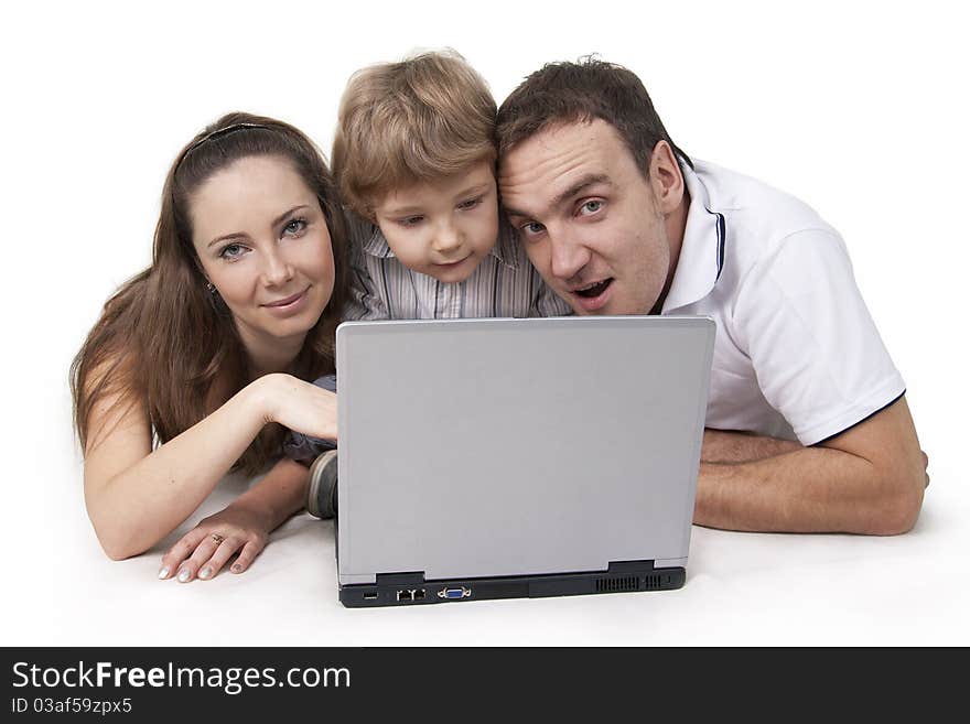 Young family lying on a floor with the computer on white isolation. Young family lying on a floor with the computer on white isolation