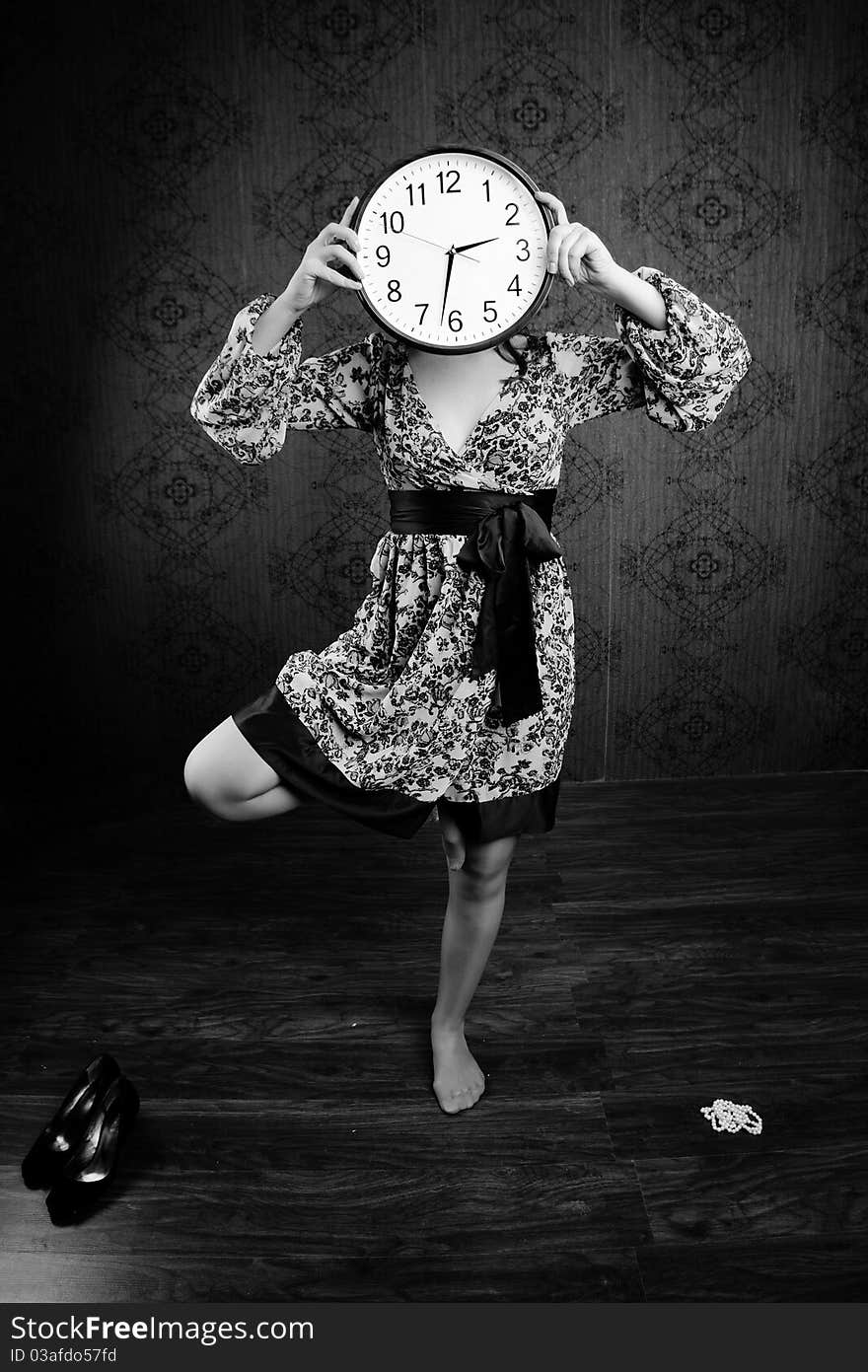 An black-and-white image of a woman with a big clock. An black-and-white image of a woman with a big clock