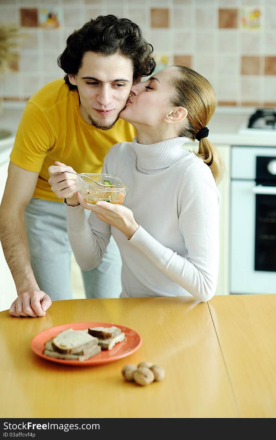 An image of young happy couple eating at kitchen. An image of young happy couple eating at kitchen