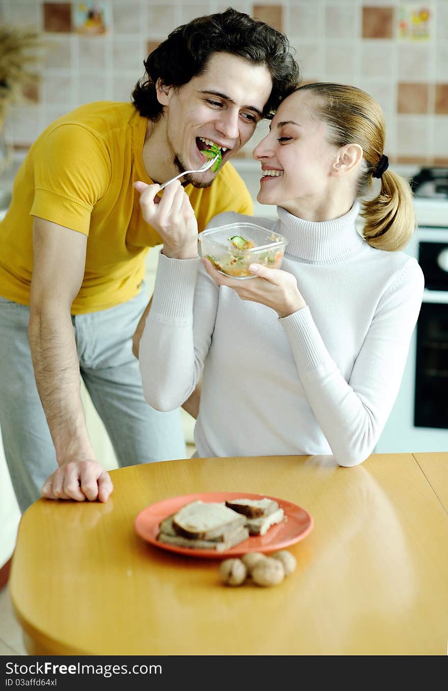 An image of young happy couple eating at kitchen. An image of young happy couple eating at kitchen