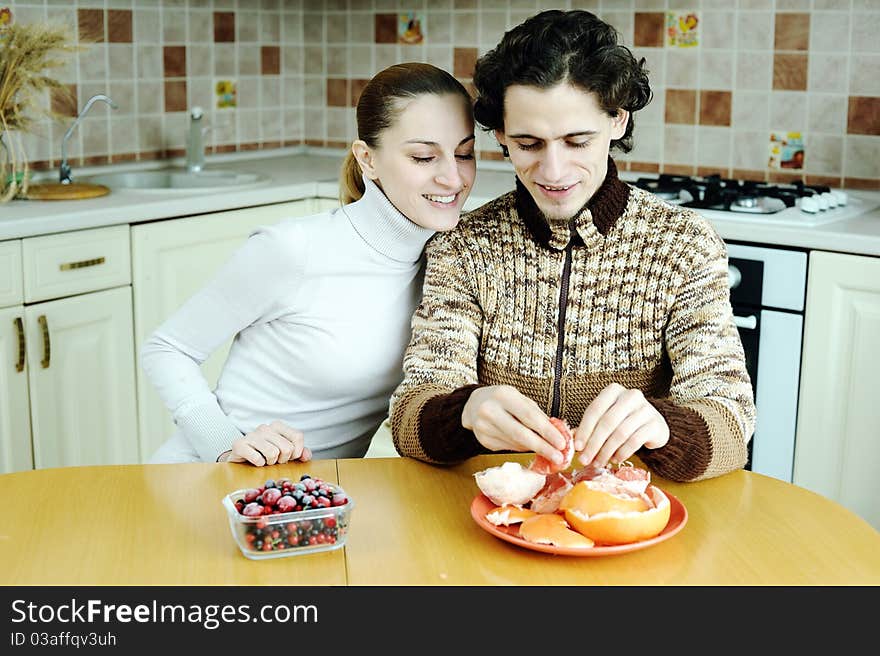 An image of young happy couple eating at kitchen. An image of young happy couple eating at kitchen