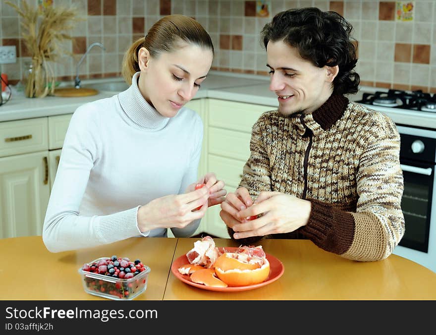 An image of young couple eating at kitchen. An image of young couple eating at kitchen