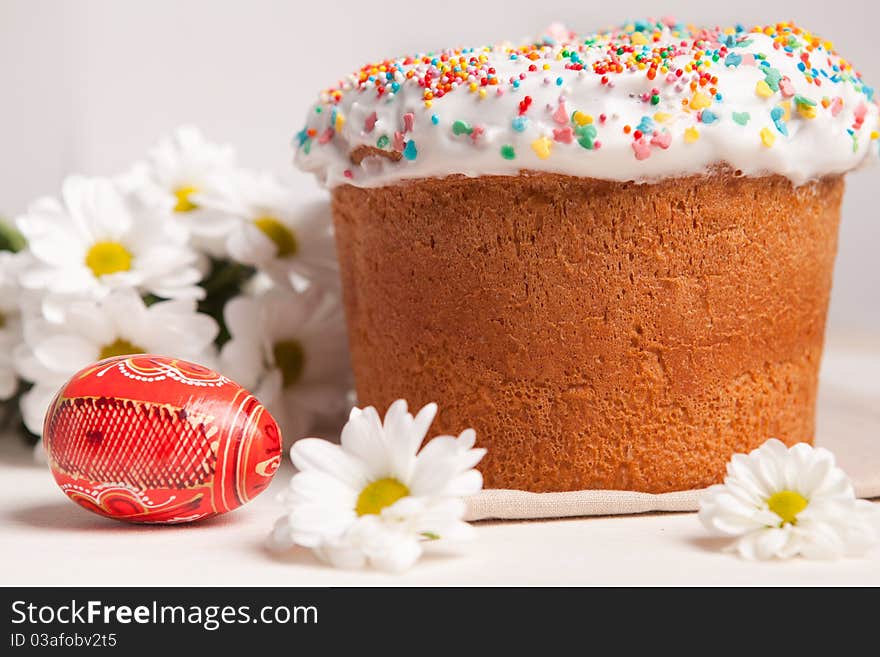 Easter cake and white flowers, red egg