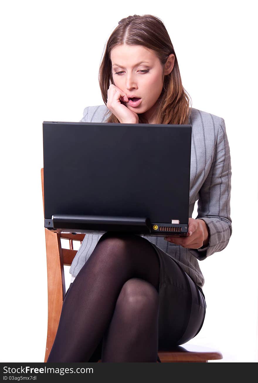 This is the studio portrait of young attractive woman with laptop surprised by stuff on the screen. This is the studio portrait of young attractive woman with laptop surprised by stuff on the screen.