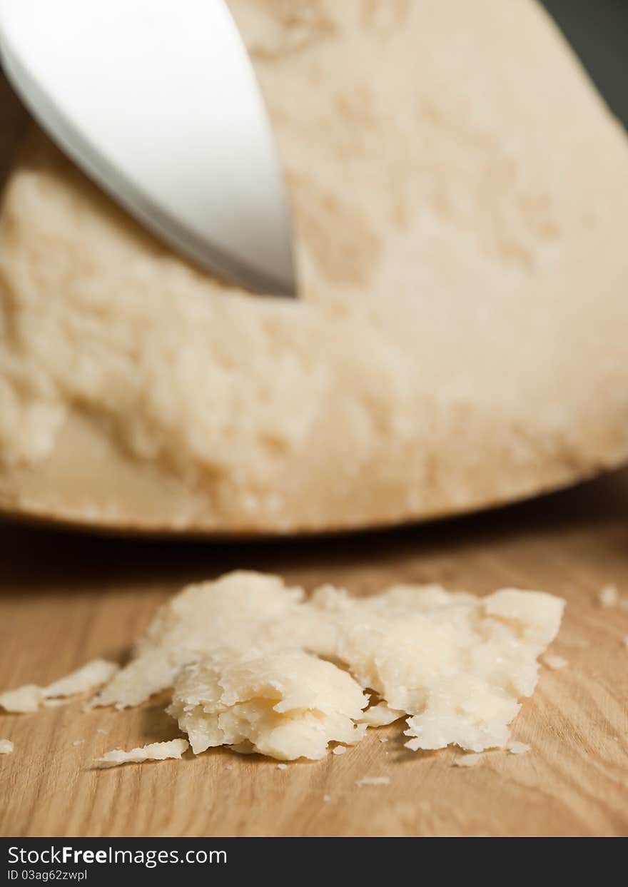 Slices of Italian parmesan with a knifein the background.