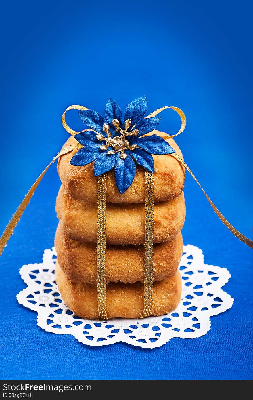 Stack of shorthbread cookies tied with golden ribbon on blue background. Stack of shorthbread cookies tied with golden ribbon on blue background