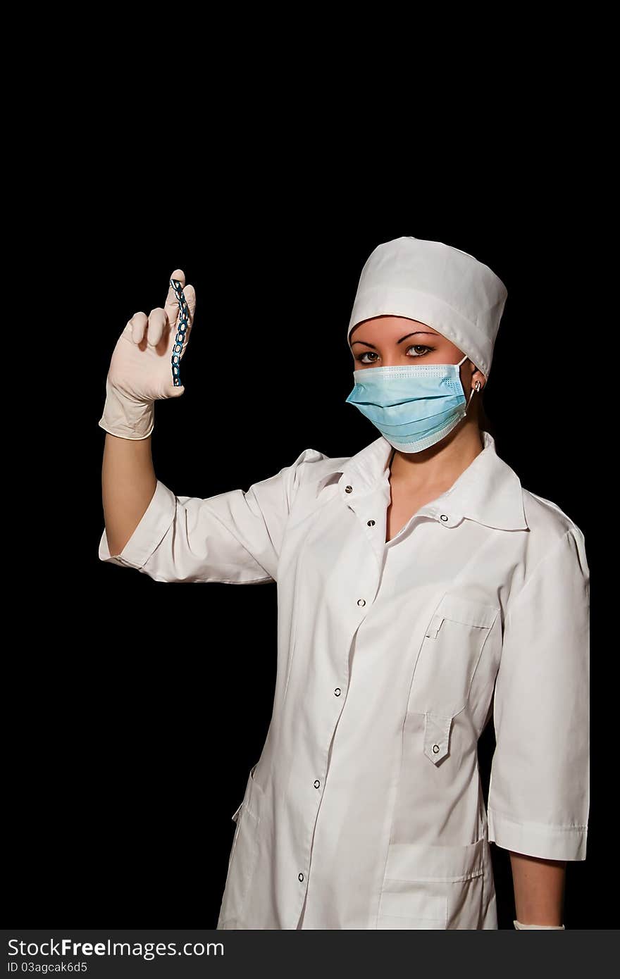 Surgeon holding plate for osteosynthesis isolated on black