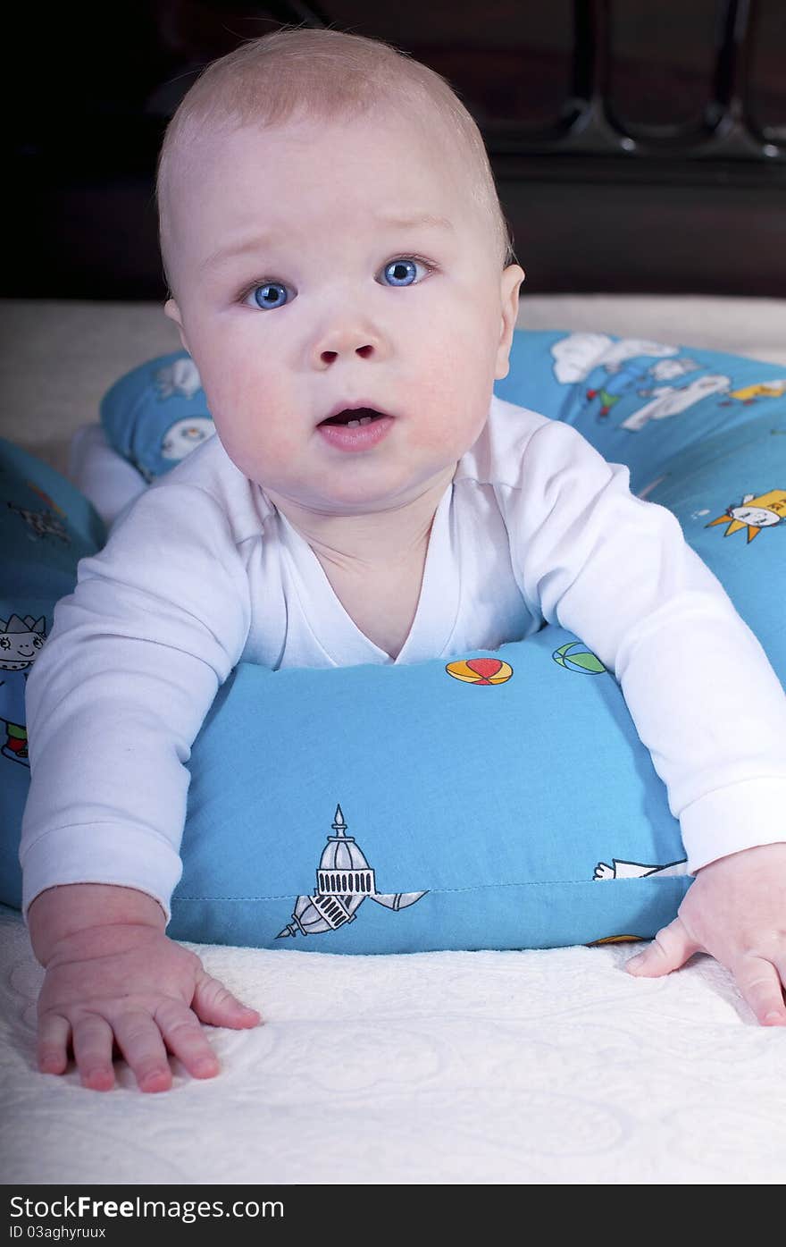 Baby with blue eyes crawling on the big bed. Baby with blue eyes crawling on the big bed.