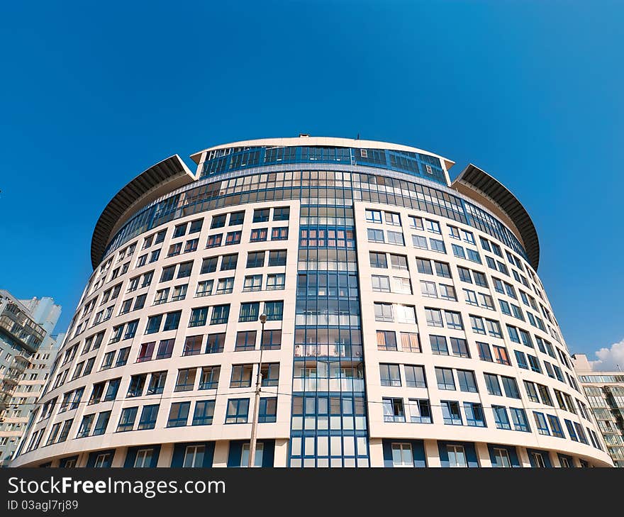 Round dwelling house with garret on the blue sky background