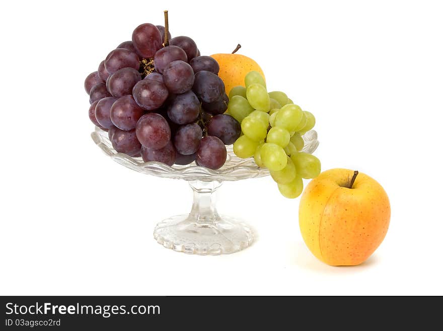 Fruits in glass vase on white background