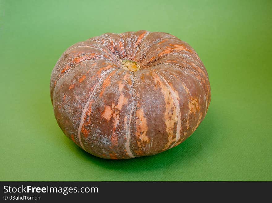 Ripe fresh raw pumpkin isolated on green