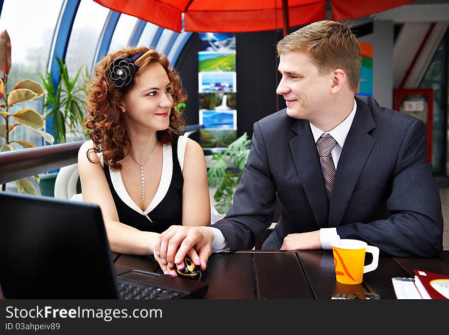 Young man and woman looking affectionately into each others eyes while sitting at a table in a cafe for lunch. Young man and woman looking affectionately into each others eyes while sitting at a table in a cafe for lunch