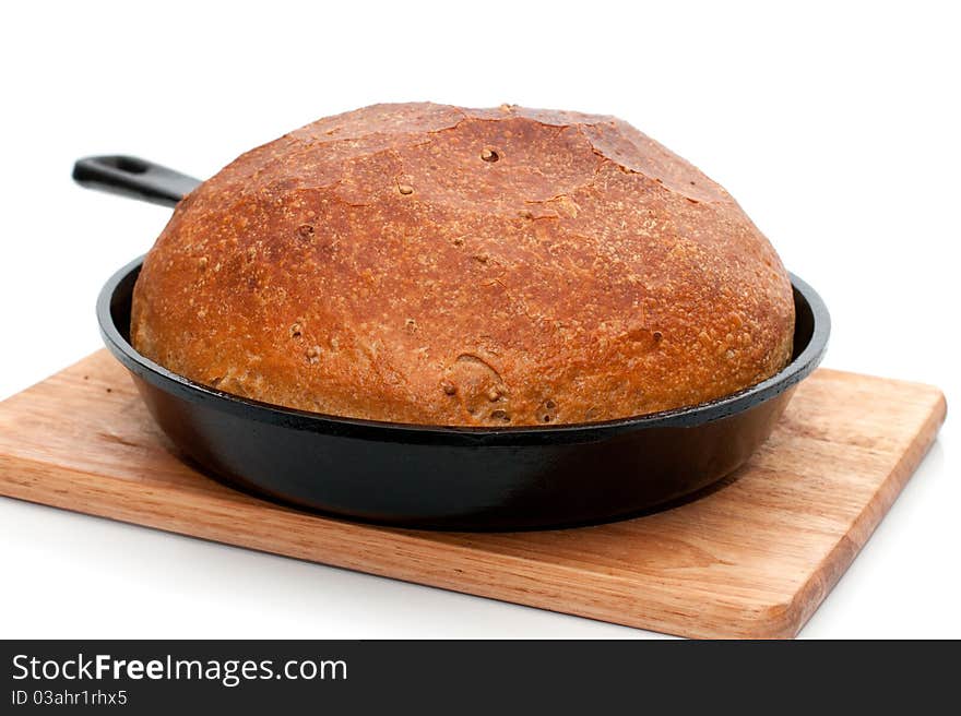 Home-made bread in frying pan isolated on white background with shadow