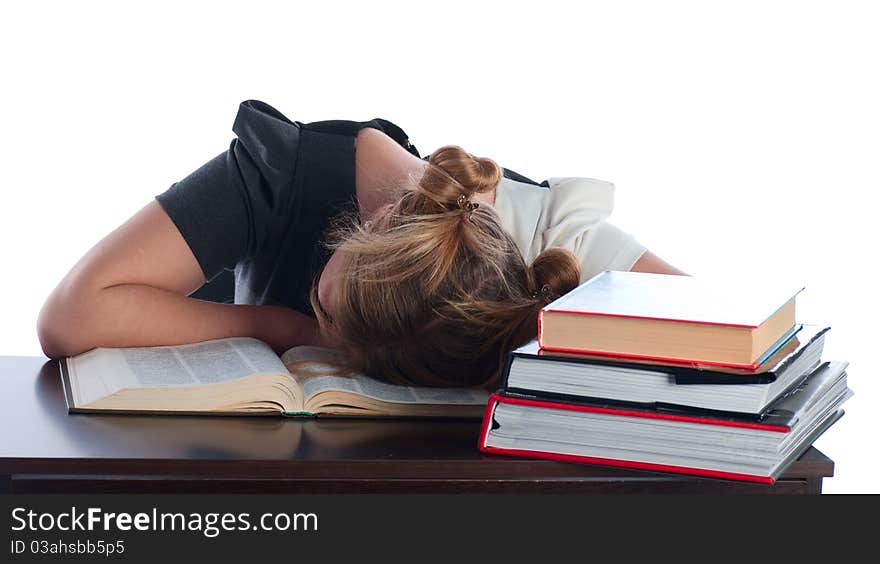 The young student has fallen asleep behind very difficult and boring textbook