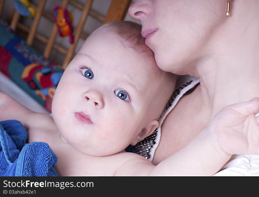 is sitting on his mother's arms. is sitting on his mother's arms.